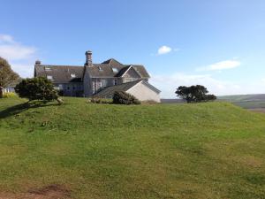 a large house on top of a grassy hill at The Downs, Thurlestone, South Devon, close to several beaches in Kingsbridge