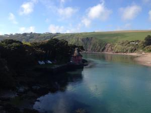a river with a small house in the middle of it at The Downs, Thurlestone, South Devon, close to several beaches in Kingsbridge