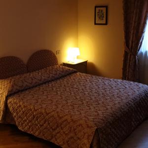 
a hotel room with a bed and a lamp at Affittacamere Mazzini 78 in Grosseto
