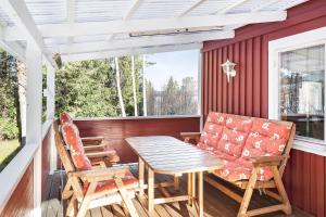 un patio con mesa y sillas en un porche en Backnäsgården, en Sandöverken