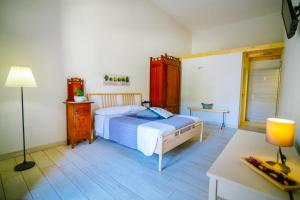 una camera con letto, scrivania e lampada di Ciatu Miu a Noto