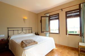 een slaapkamer met een wit bed en 2 ramen bij LES CAPELLES 37 in L'Estartit +19 foto's