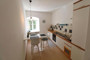 a small kitchen with a table and chairs in it at Maria von Buol - Wohnen in Kaltern in Caldaro