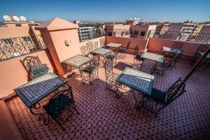 eine Gruppe von Tischen und Stühlen auf einem Balkon in der Unterkunft Moroccan House in Marrakesch