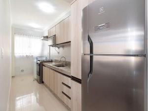 cocina con nevera de acero inoxidable en Aluguel Apartamento 2 quartos sendo 1 suíte Bombas/SC, en Bombinhas