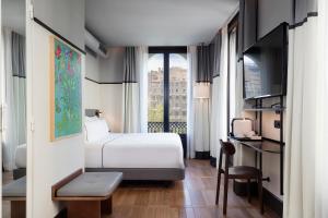 una camera d'albergo con letto e finestra di Praktik Èssens a Barcellona