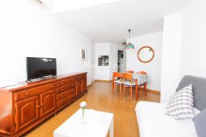 a living room with a couch and a tv at Mar del Sur Apartamentos- Piscina y Playa - PARKING GRATIS in Benalmádena