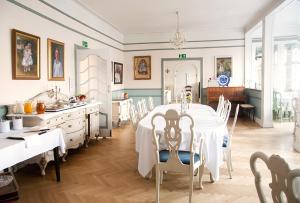 a dining room with a white table and chairs at Langesund Bad in Langesund