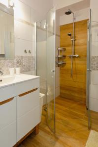 シュチルクにあるSun&Sport Apartament TURKUS w super lokalizacji niedaleko wyciąguのシャワーと白い洗面台を備えたバスルーム +7枚の写真
