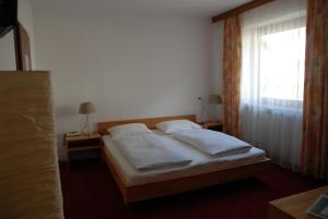 sypialnia z łóżkiem z 2 poduszkami i oknem w obiekcie Landhotel Anna w mieście Silandro