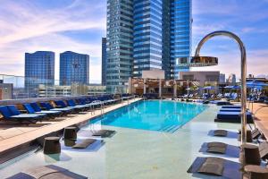 a pool on the roof of a building with chairs at Stay Together Suites on The Strip - 1 Bedroom Apartment with View 656 in Las Vegas