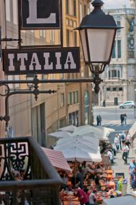 una strada con ombrelli e un cartello italiano di Hotel Italia a Cagliari