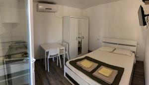 a small bedroom with a bed and a table at Villaggio Le Venelle in Rio Marina