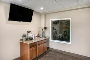 a room with a counter with a tv on the wall at Rodeway Inn Bristol near Sesame Place in Levittown