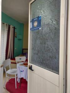 une porte menant à une chambre avec une table et une chaise dans l'établissement Private room historic center Elbasan, à Elbasan