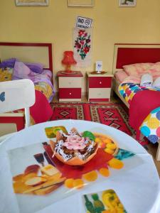 a room with two beds and a table with a dessert on it at Private room historic center Elbasan in Elbasan