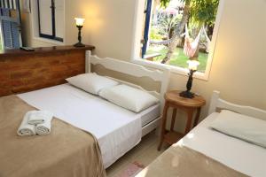 2 camas en una habitación con ventana en Pousada Solar Dos Corais, en Búzios