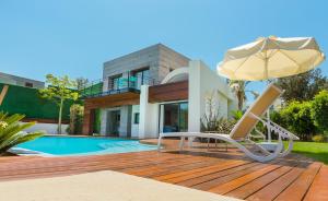 un patio con una silla y una sombrilla junto a la piscina en Alya Sierra Villa Hotel, en Muğla
