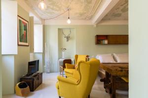 sala de estar con sillas amarillas y mesa en Duomo Luxury Suite - by MyHomeInComo, en Como