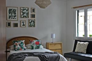 um quarto com uma cama, uma cadeira e uma janela em Feel Aveiro - Church View em Aveiro