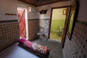 a small bathroom with a toilet and a mirror at Dar Chourouk in Fez