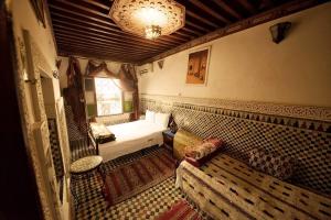a small bedroom with a bed and a couch at Dar Chourouk in Fez