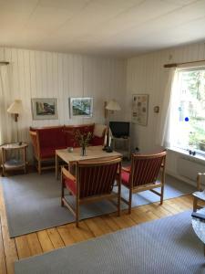 a living room with a table and chairs and a couch at Midtvejshuset in Rønne