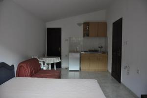 a kitchen and a living room with a couch and a table at Apartmani Novakovic in Petrovac na Moru