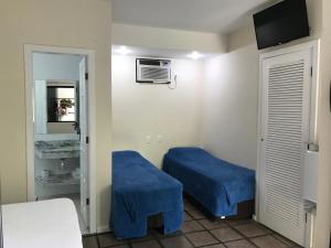 a room with two blue beds and a mirror at Pousada Agua Viva in Abraão