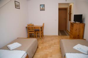 um quarto com duas camas e uma mesa e uma sala de jantar em Pokoje Gościnne Dom św. Szymona na Cracóvia