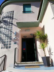 un bâtiment avec une porte et des plantes devant lui dans l'établissement Hotel Caprice, à Marina di Massa