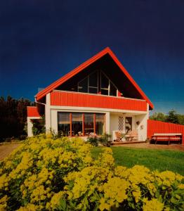 una casa roja y blanca con un montón de flores amarillas en Úlfarsfellsvegur 20, 113 Rvk Birkihlid en Reikiavik