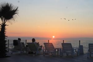 a group of people sitting in chairs watching the sunset at Panamericana Hotel Arica in Arica