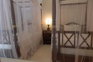 a bedroom with a bed and a table with a lamp at Orchard House Galle in Galle