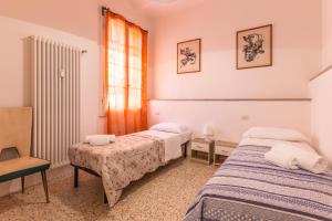 um quarto com 2 camas e uma cadeira em Matteotti, Bologna by Short Holidays em Bolonha