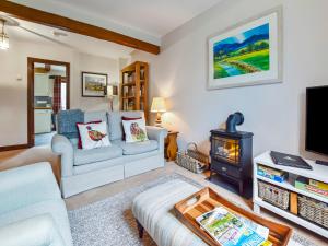 a living room with a couch and a wood stove at Stepping Stones in Blockley