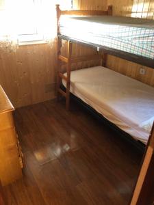 a bunk bed in a room with a wooden floor at urb el refugio , brañavieja-alto campoo in Brañavieja