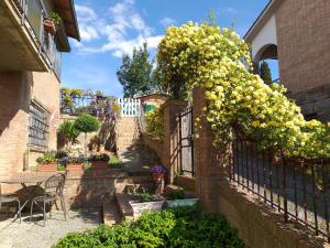 un jardin avec des fleurs jaunes sur une clôture dans l'établissement Casa SoleLuna, à Sienne