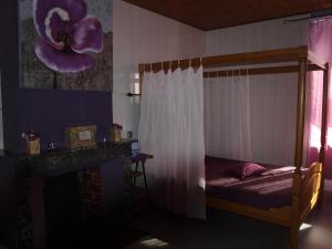 ein Schlafzimmer mit einem Bett mit einer Blume an der Wand in der Unterkunft GITE ANNA in Le Châtelet-sur-Sormonne