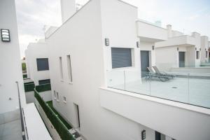 a view from the balcony of a white building with a glass window at Villa Deluxe La Marina Beach in Alicante