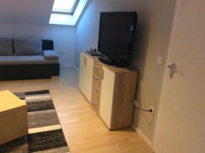 una sala de estar con TV de pantalla plana en una cómoda en Ferienwohnung Heddesheim, en Heddesheim