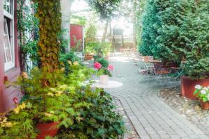 a garden with tables and chairs and plants at Hotel Deutsches Haus in Heiligenhafen