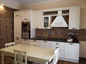 a kitchen with white cabinets and a wooden table at La casa della sposa in Trani