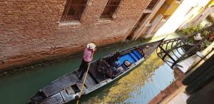 una mujer está remando un barco en un canal en Scalon del Doge, en Venecia