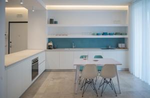 a white kitchen with a table and chairs at Il Cavaliere Bed and Breakfast in Caserta