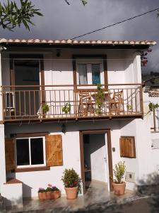 ein weißes Haus mit einem Balkon und Topfpflanzen in der Unterkunft Apartamento El Almendrero in El Pueblo