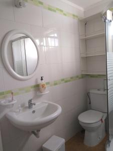 ein Badezimmer mit einem Waschbecken, einem WC und einem Spiegel in der Unterkunft Apartamento El Almendrero in El Pueblo