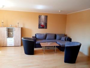 sala de estar con sofá azul y mesa en Ferienwohnung "Kieperhof", en Dielmissen