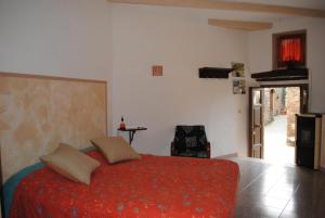 a bedroom with a red bed and a chair at Essenza in Pitigliano