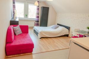 a living room with a red couch and a bed at Maritima in Krynica Morska
